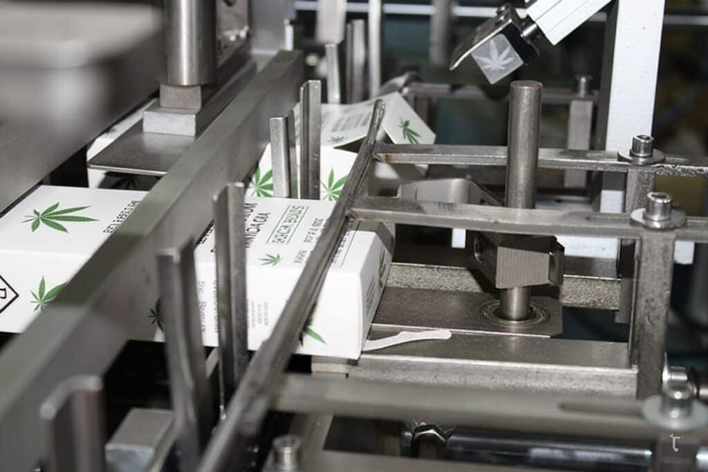 Assorted cannabis packaging: dropper bottle cartons, pre-roll drawer box, vape tin cases, and clear blister trays; child-resistant and odor-proof.